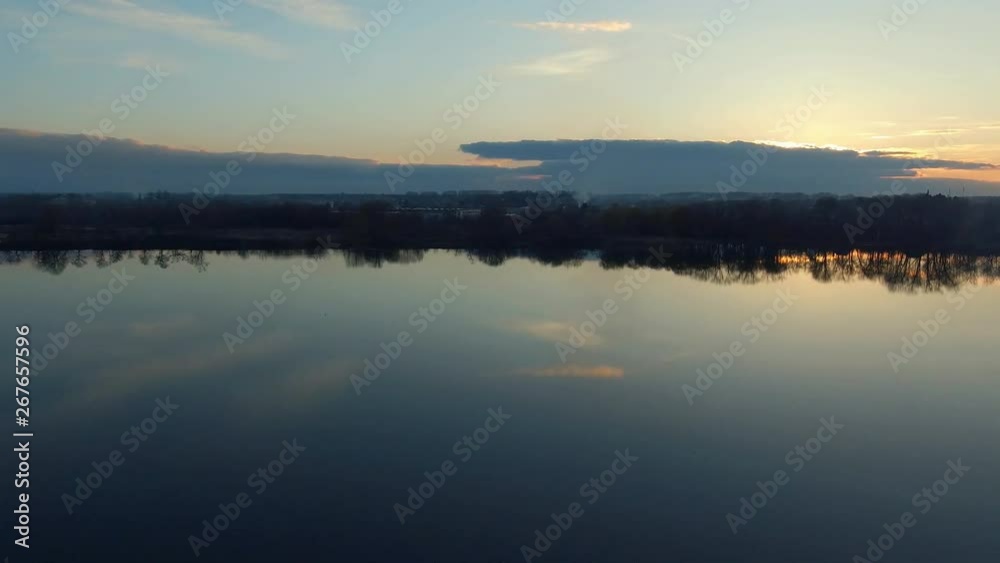 Romantic water landscape with sunset sky. Smooth surface of the wide river with reflection. Calm quiet weather. Aerial survey- flight of drone Romantic water landscape with sunset sky. Smooth surface of the wide river with reflection. Calm quiet weather. Aerial survey- flight of drone