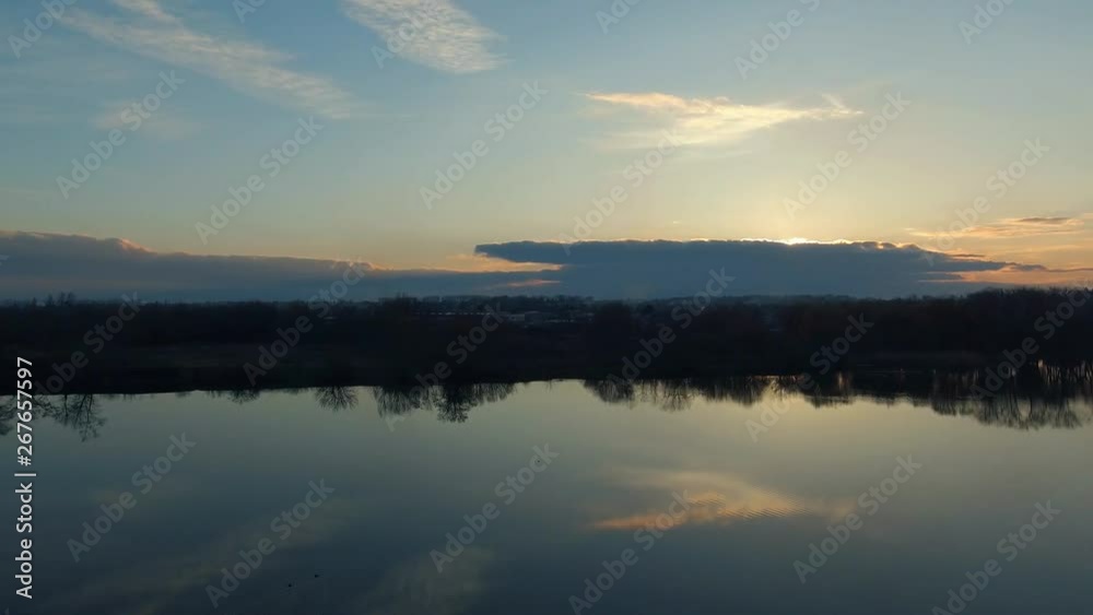 Romantic water landscape with sunset sky. Smooth surface of the wide river with reflection. Calm quiet weather. Aerial survey- flight of drone Romantic water landscape with sunset sky. Smooth surface of the wide river with reflection. Calm quiet weather. Aerial survey- flight of drone