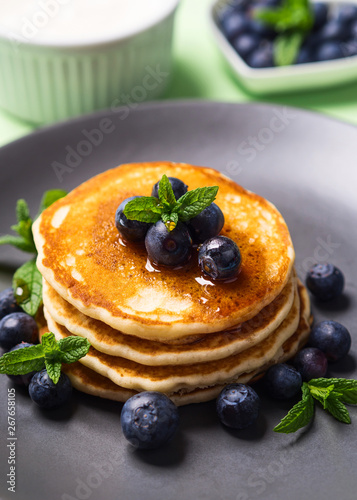 Stack of home made pancakes served with fresh berries and maple syrup. Simple and delicious breakfast