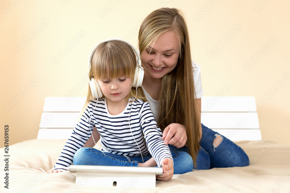 Mother and daughter using tablet together on the bed. Mother and daughter using tablet together on the bed.