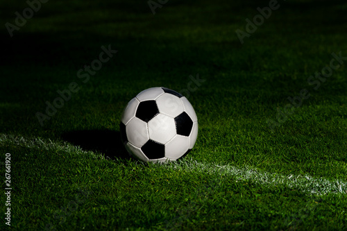soccer ball classic in black and white on penalty spot on green artificial turf