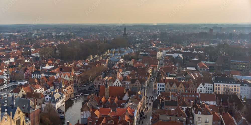 Bruges city skyline with red tiled roofs, Rozenhoedkaai (Quay of the Rosary) canal and Saint Magdalene Church tower in winter day. View to Bruges medieval cityscape from the top of the Belfry.
