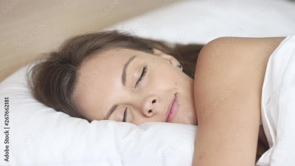 Calm woman sleeping well in comfortable bed on soft pillow