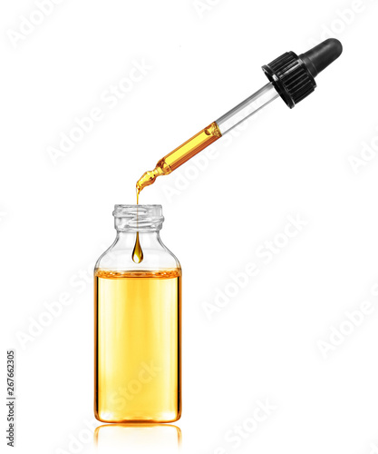 Drop drops from a pipette in a cosmetic bottle, isolated on white background