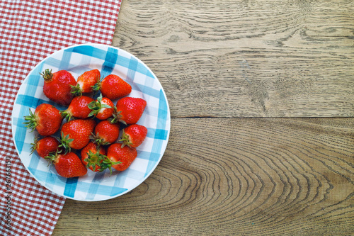 Strawberries on a checkered plate. Top view with copy space.