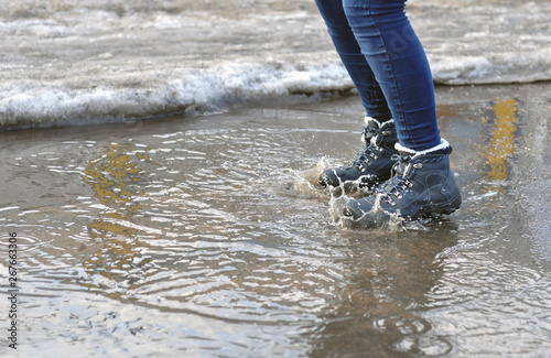 Girl jumping in a puddle and make spray