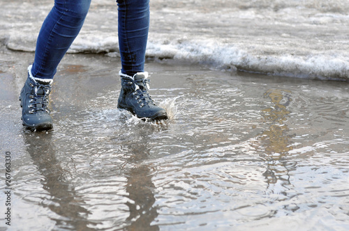 Girl jumping in a puddle and make spray