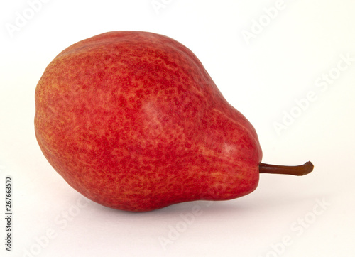 Appetizing fragrant yellow with bright red speckled pear with a brown twig on a white background
