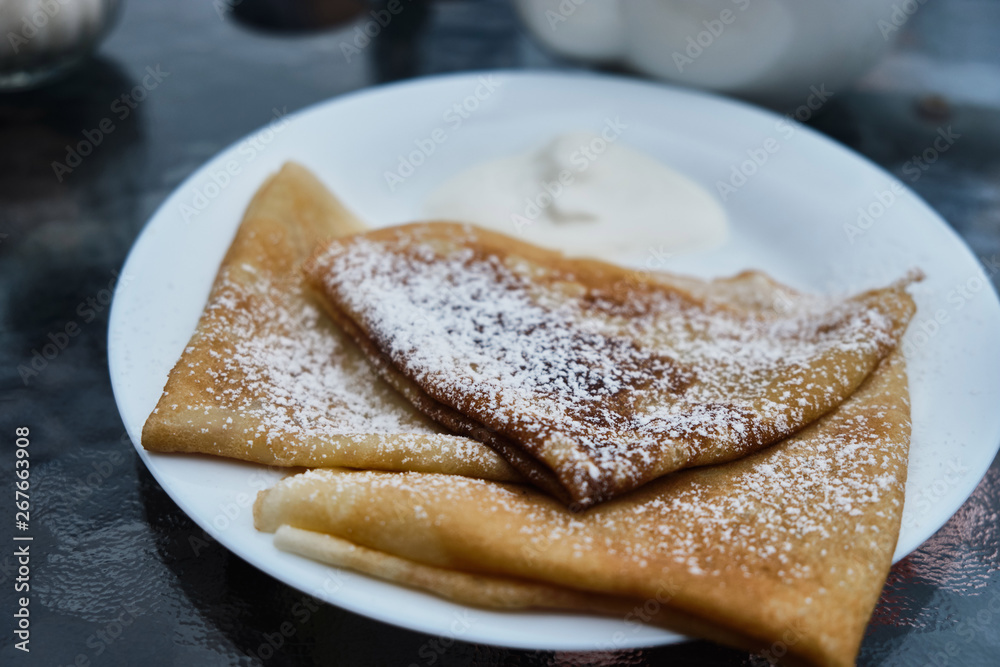 Pancakes in powdered sugar on plates Pancakes in powdered sugar on plates