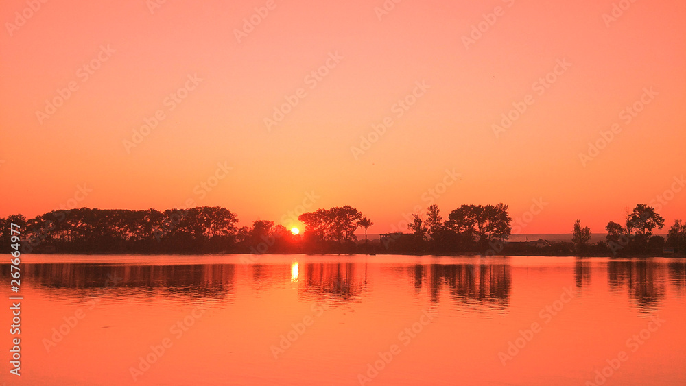 Beautiful summertime landscape with sunset over lake
