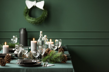 Elegant table set for christmas dinner, copy space on empty green wall
