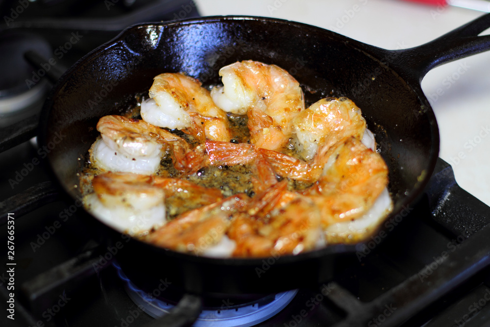 Shrimp Scampi cooking in a cast iron pan on the stove. Shrimp Scampi cooking in a cast iron pan on the stove.