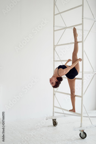 The splits in the air on metal poles. Gymnast in black tights. Flexibility