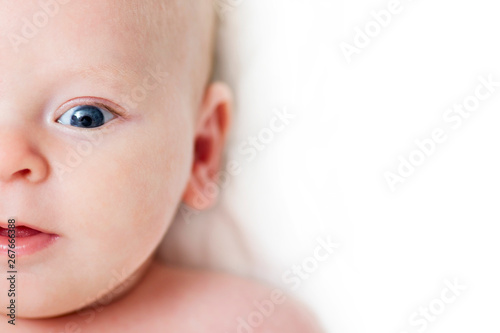 Baby infant close-up portrait. Happy baby face over light background. Looking at camera. Copy space