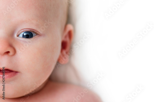 Baby infant close-up portrait. Happy baby face over light background. Looking at camera. Copy space