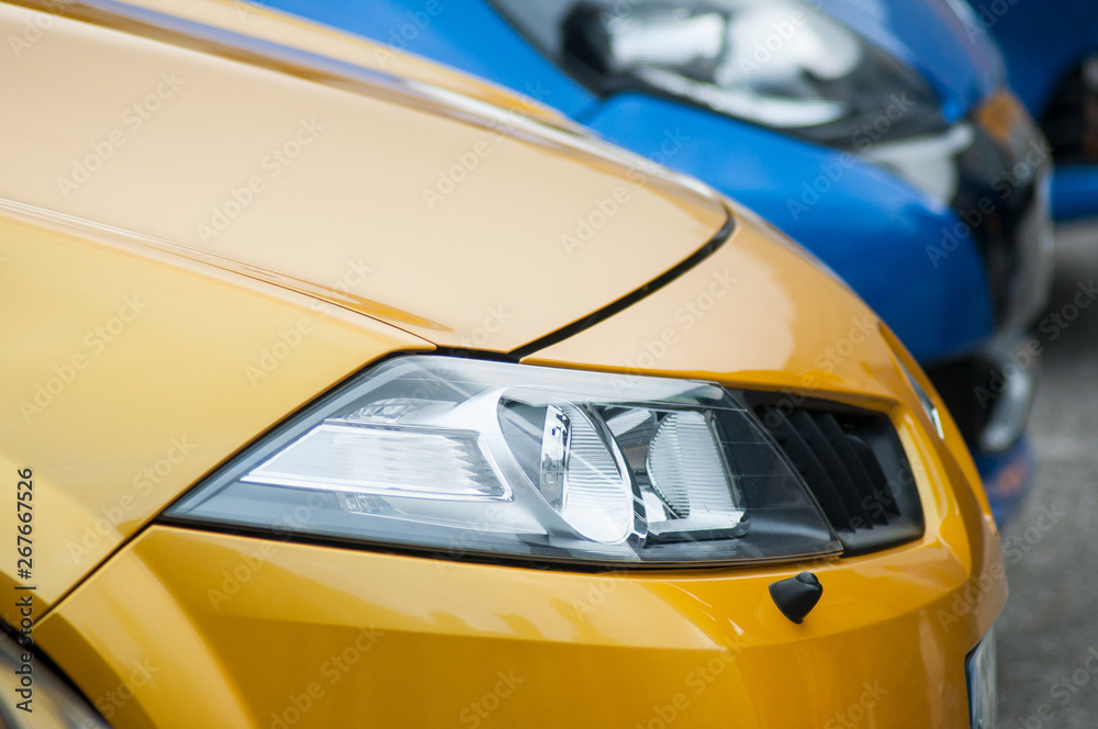  closeup of yellow cars front parked in the street