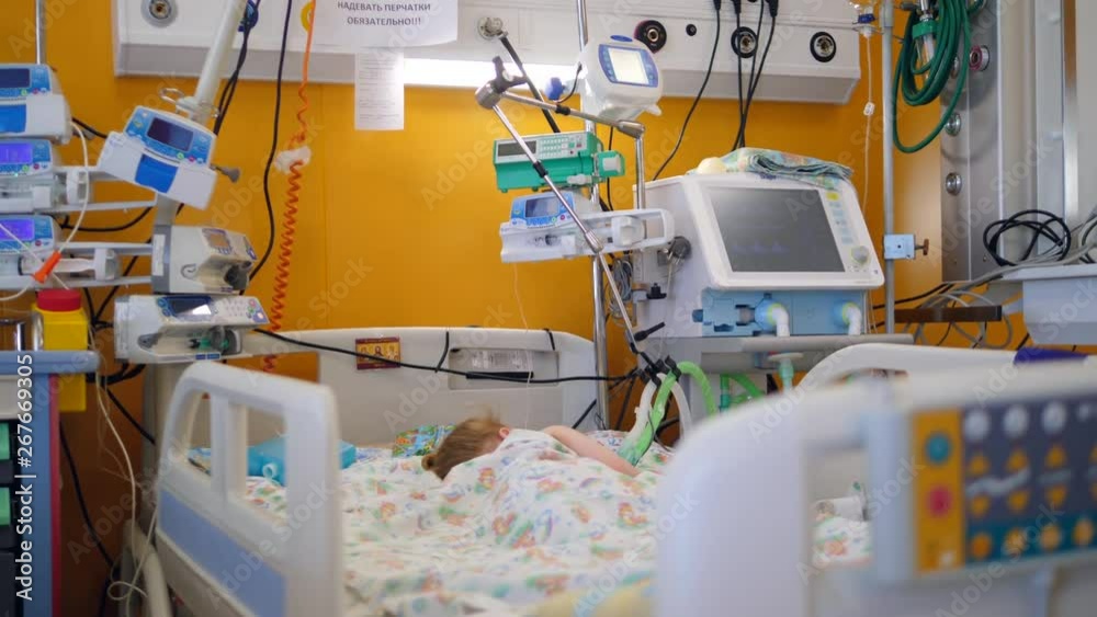 A child is sleeping on a bed in a medical unit