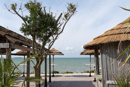 Fototapeta Naklejka Na Ścianę i Meble -  Blue sky and straw umbrella on a beautiful tropical beach cafe coffee restaurant background