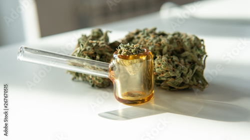 glass smoking pipe and marijuana buds close-up. © contentdealer