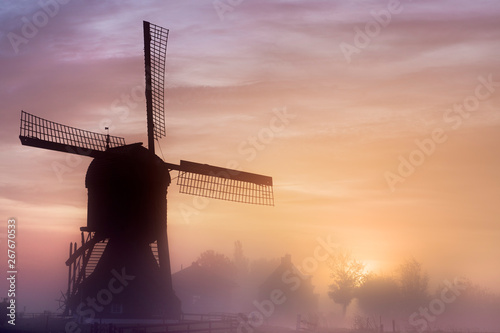 Old wooden windmil at sunrise photo