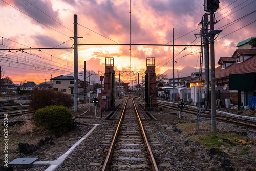 Straight railroad track under colourful sky at sunset. Fujikawaguchiko, Japan.
