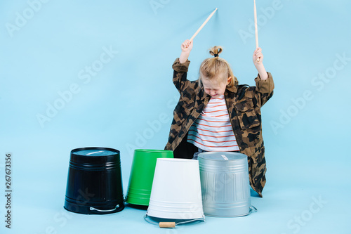 Fototapete Little boy using drumsticks on iron and plastic buckets