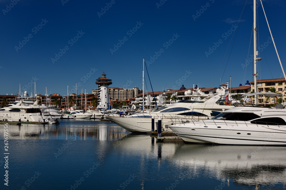 Yachts and sailboats moored at the Puerto Vallarta Marina with El Faro Lighthouse