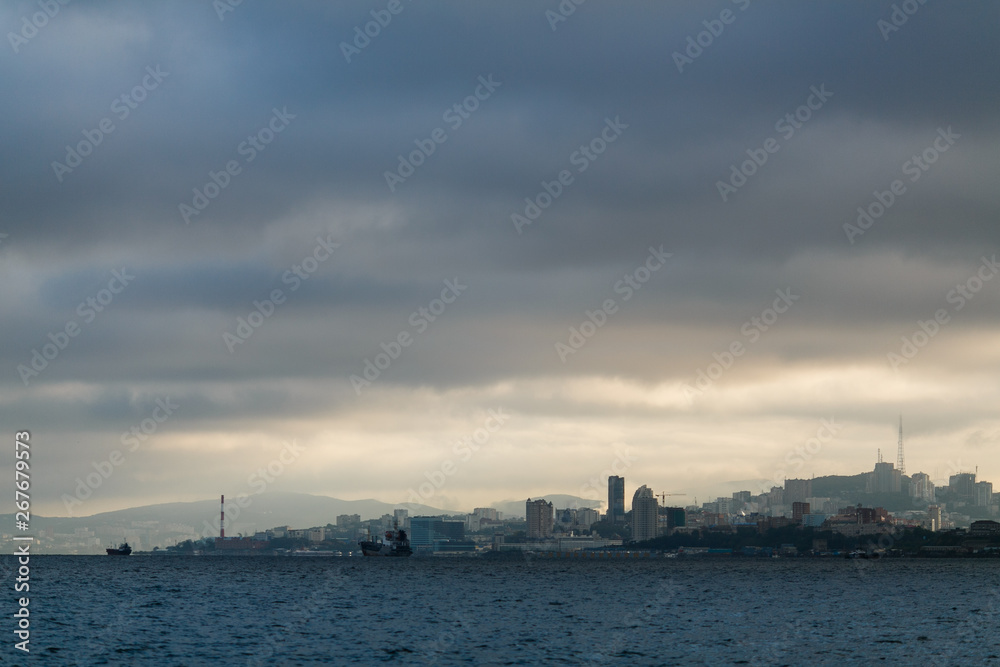 The coastline of Vladivostok from the sea. Vladivostok in inclement weather. The sea facade of Vladivostok.