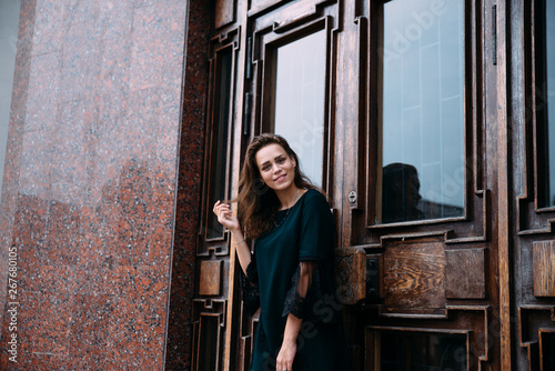 Young girl in green dress near old big building door photo