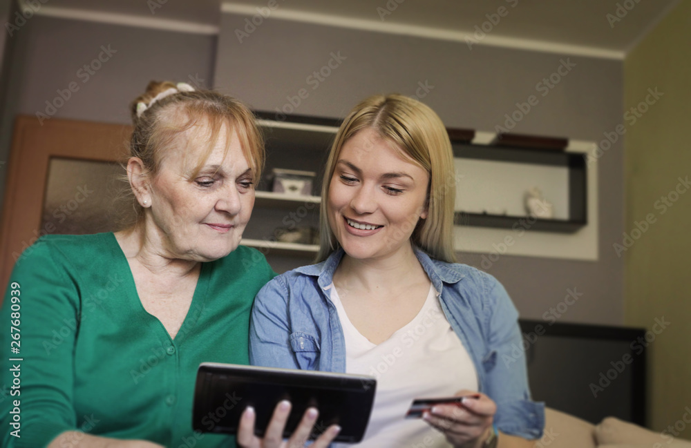 Senior woman and her adult daughter shopping online at home. Senior woman and her adult daughter shopping online at home.