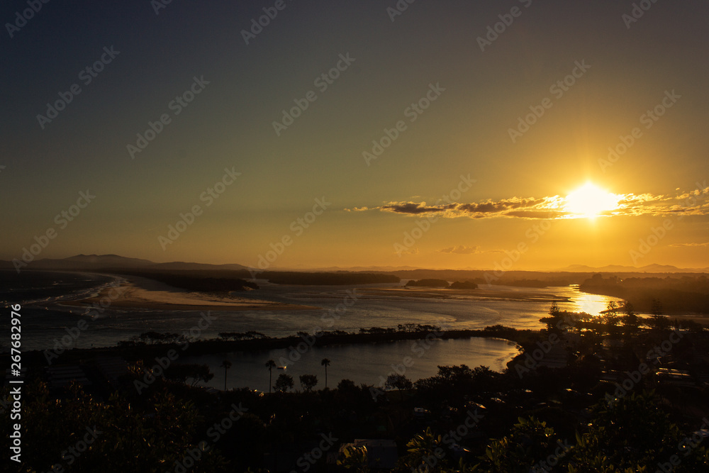 Fototapeta premium Flat sand dunes at delta of Nambucca river entering Pacific ocean through wide sandy beach of Australian coast around Nambucca heads town at sunset - aerial view
