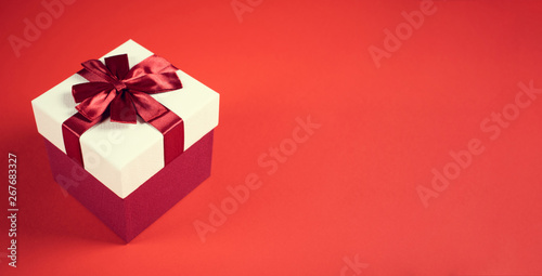 Beautiful present box on red background.