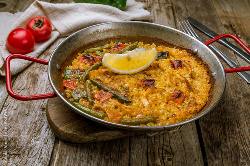 paella with squid on wooden background