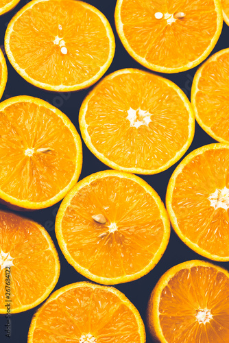 Orange background. Closeup of half cut fruits