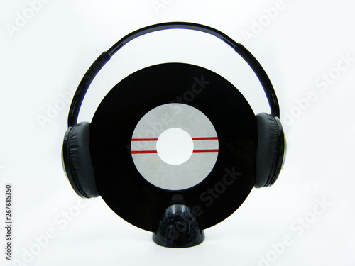 Vinyl single record with black headphones on white background