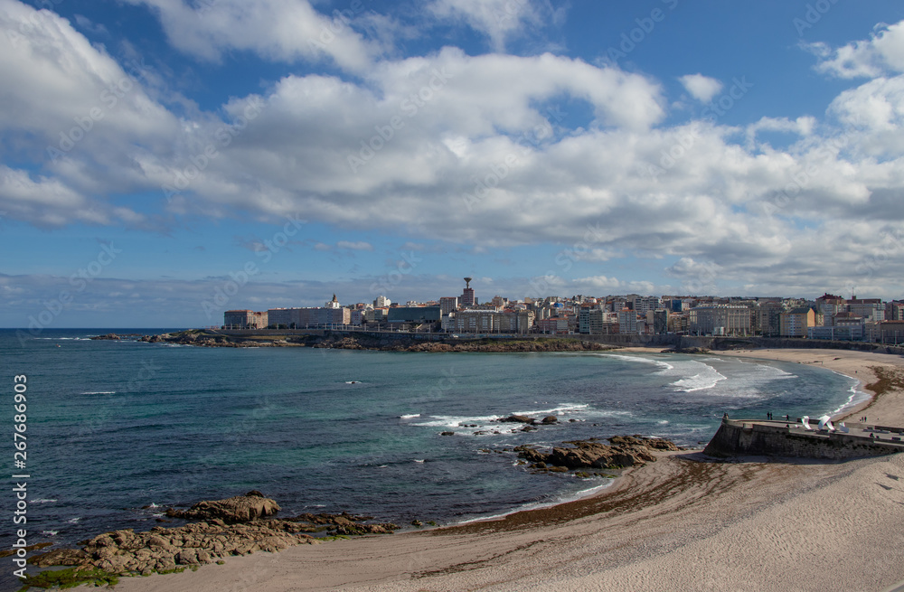 Beautiful view of the beaches of Riazor and Orzán in A Coruña, Galicia with the buildings of the city and the promenade.