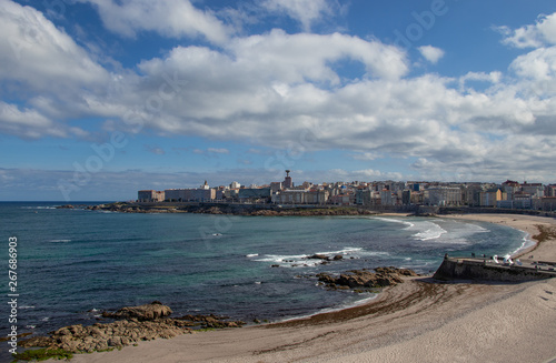 Beautiful view of the beaches of Riazor and Orzán in A Coruña, Galicia with the buildings of the city and the promenade.