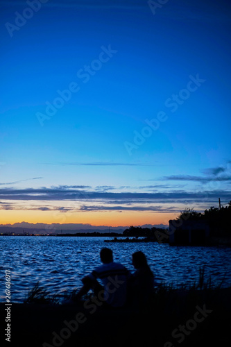 Couple in love contemplate the Sunset in the Albufera of Valencia