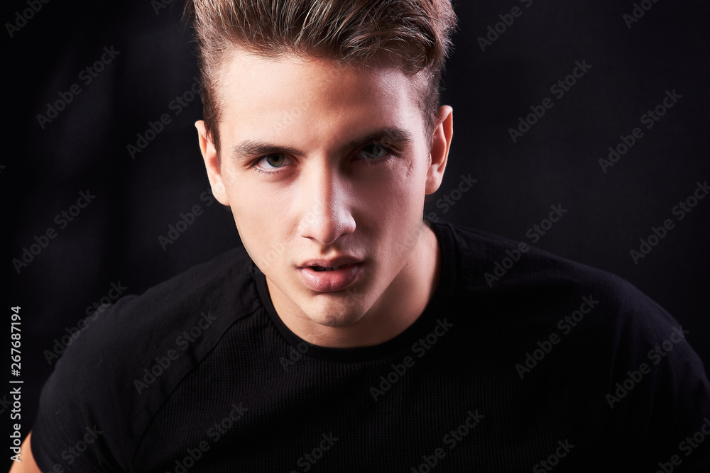 Fashion portrait of elegant young handsome man isolated on black background