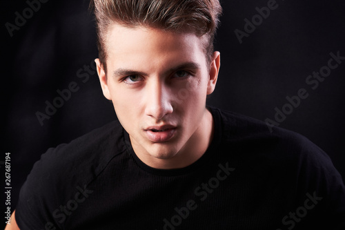 Fashion portrait of elegant young handsome man isolated on black background