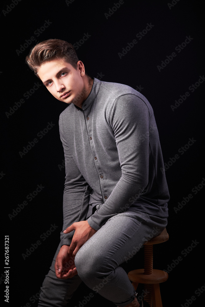 Fashion portrait of elegant young handsome man isolated on black background