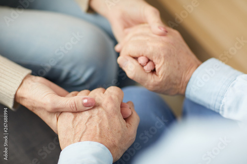 Closeup of senior couple holding hands supporting each other, copy space