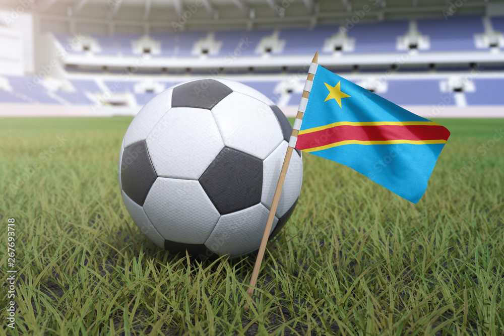 Naklejka premium Democratic Republic of the Congo flag in stadium field with soccer football