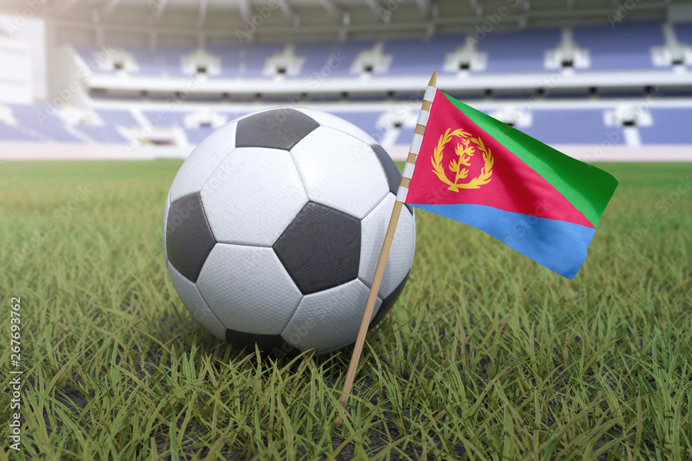 Naklejka premium Eritrean flag in stadium field with soccer football