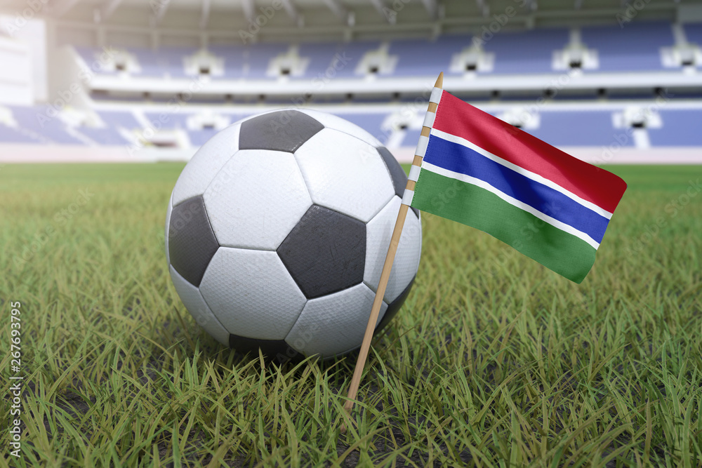 Naklejka premium Gambian flag in stadium field with soccer football