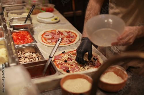 Man making pizzas at table, closeup view