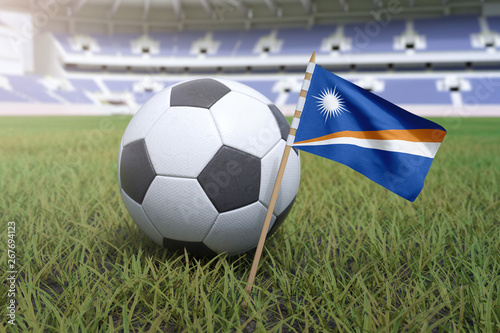 Marshall Islands flag in stadium field with soccer football