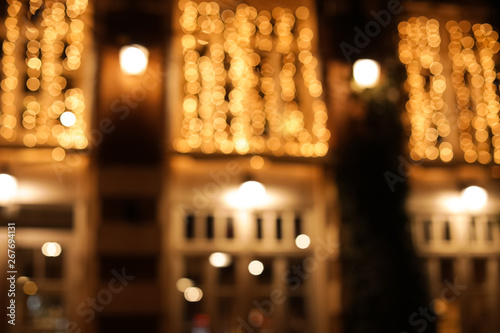 Blurred view of building with beautiful street lights at night. Bokeh effect