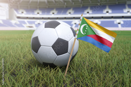 The Comoros flag in stadium field with soccer football