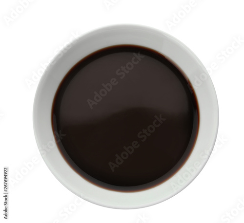 Bowl of soy sauce on white background, top view